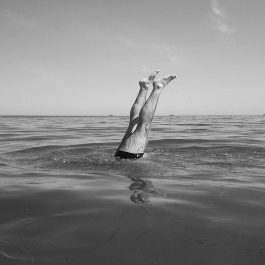Legs of a person diving into the ocean